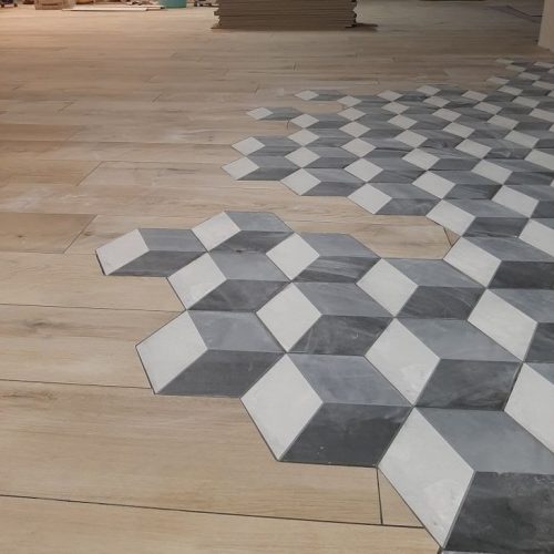 Top End Tiling NZ: Unique floor tiling design with geometric patterns transitioning to wood-look planks.