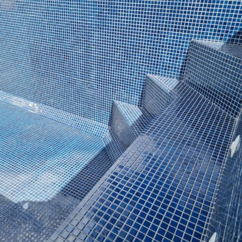 outdoor tiling Expert pool tiling by Top End Tiling, showcasing a beautifully finished blue mosaic around a Takapuna swimming pool.