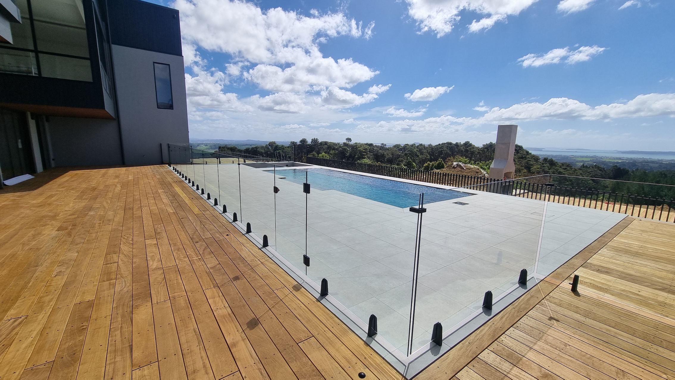 Top End Tiling: Expert tilers laying elegant pool surrounds at a luxury property in Albany Auckland.