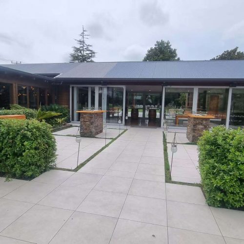 Beautiful vineyard outdoor tiling by Top End Tiling featuring non-slip stone pavers integrated with lush grass.