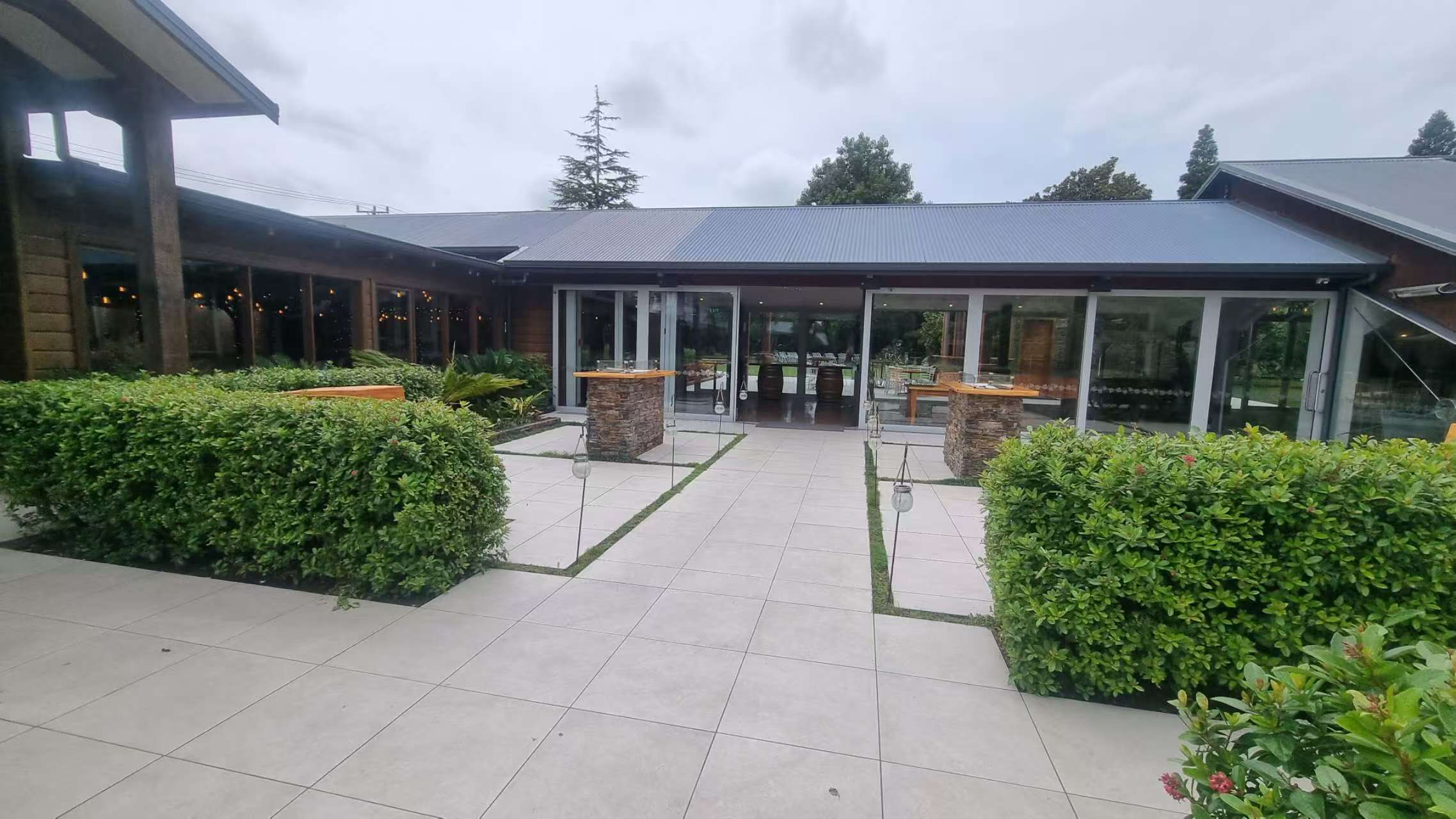 Beautiful vineyard outdoor tiling by Top End Tiling featuring non-slip stone pavers integrated with lush grass.